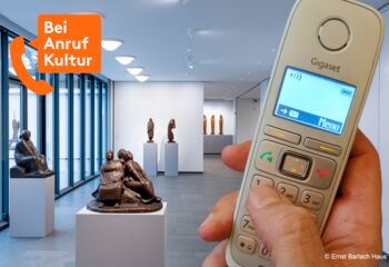 Eine Hand hält ein schnurloses Telefon. Im Hintergrund eine Ausstellungsfläche mit unterschiedlichen Skulpturen auf weißen Sockeln. Oben links in Orange ein Logo: "Bei Anruf Kultur" in einer Sprechblase, die aus einem Telefonhörer kommt.
