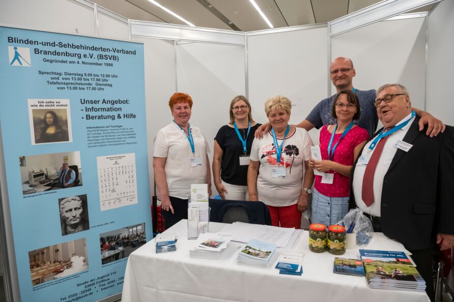 Das Bild zeigt das Team des Blinden-und-Sehbehinderten-Verbandes Brandenburg mit ihrem Infostand auf dem Louis Braille Festival 2019 in Leipzig.