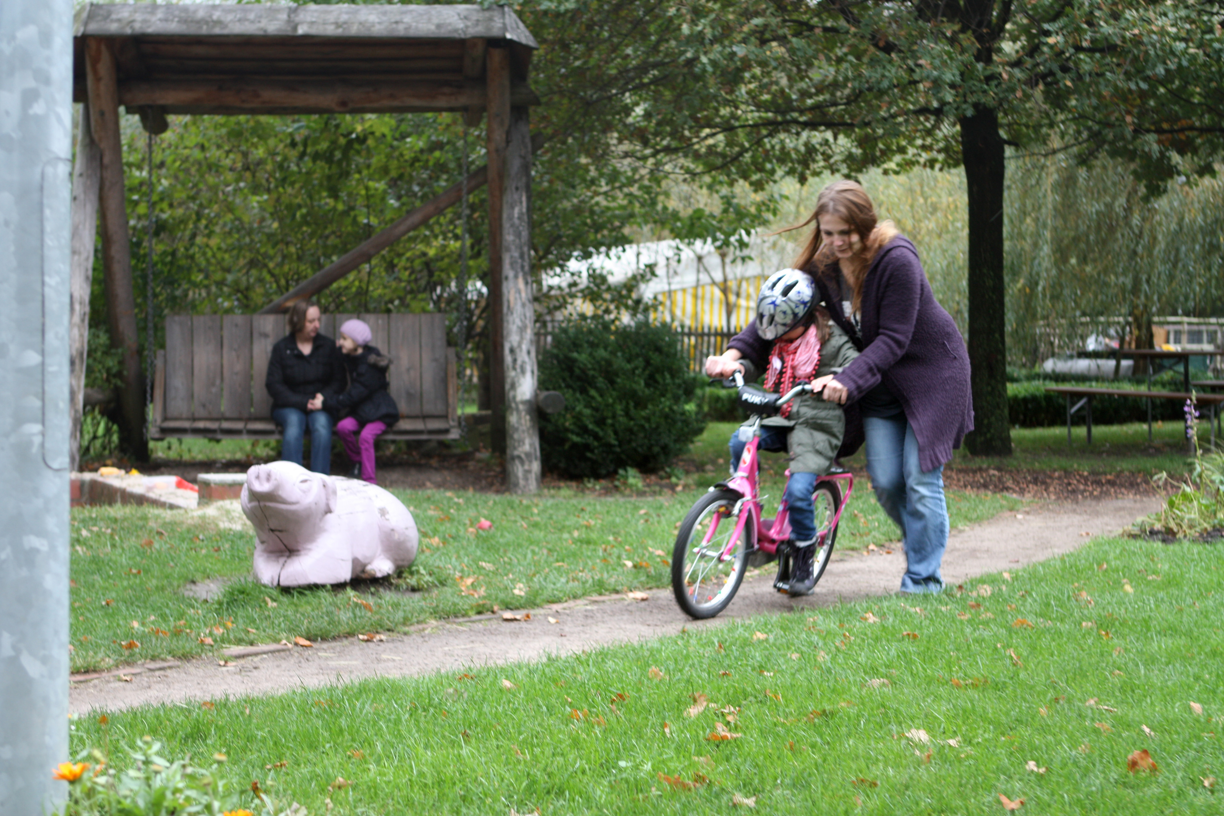 Frau hilft Mädchen beim Fahrradfahren