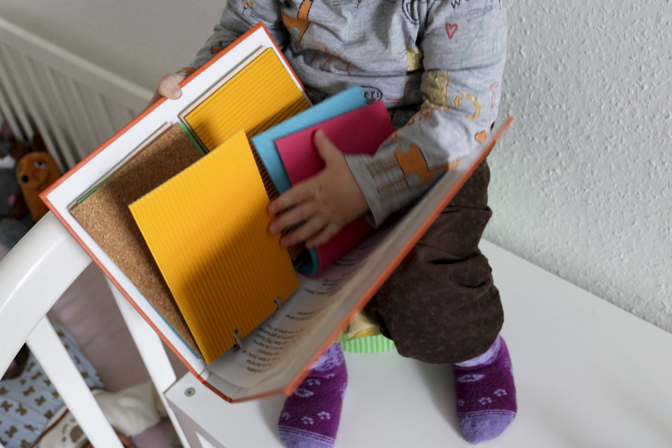 Ein kleines Mädchen ertastet das Mix-Max-Fuehlbuch